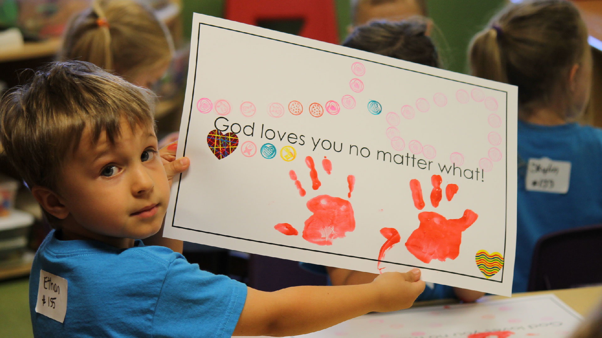 A young boy holds up a picture that he drew at Brookwood Church BrookwoodKiDs